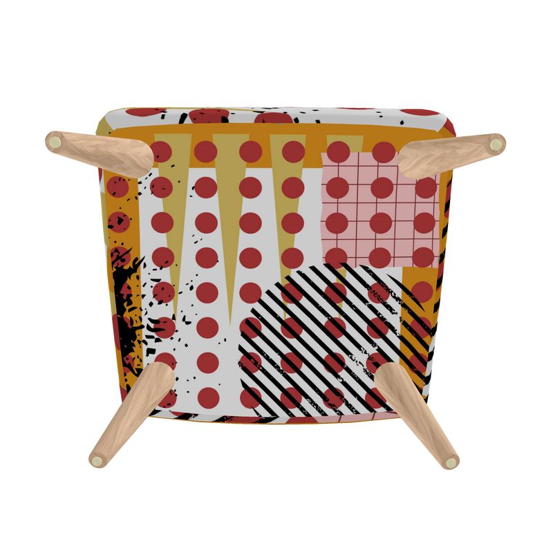 Base view Pop Art print which consists of large red circles, pink grid, long ochre spikes, black and white striped circle and golden yellow frame on armless accent chair with tapered beech wood legs.